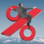 Imagem de um homem de terno sentado no símbolo da porcentagem, voando sobre as nuvens. Ideia de liberdade financeira