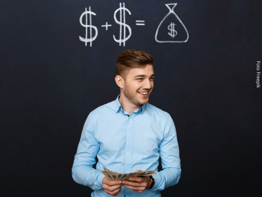 Foto de um homem jovem à frente de um quadro negro com cifrões desenhados. Conceito de economizar