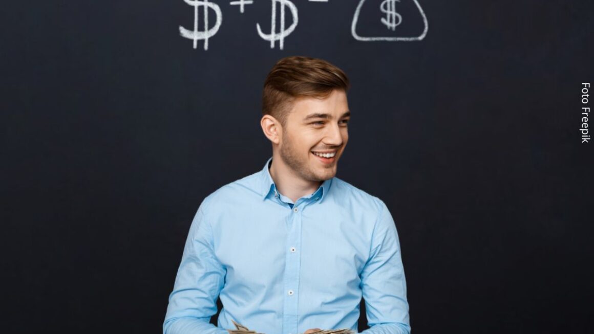 Foto de um homem jovem à frente de um quadro negro com cifrões desenhados. Conceito de economizar