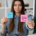Imagem de uma mulher mostrando dois post it com as palavras não e sim, dando a entender que dizer não é importante