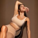 Imagem de uma mulher sentada em uma cadeira posando relaxada e parecendo estar com a autoestima em alta