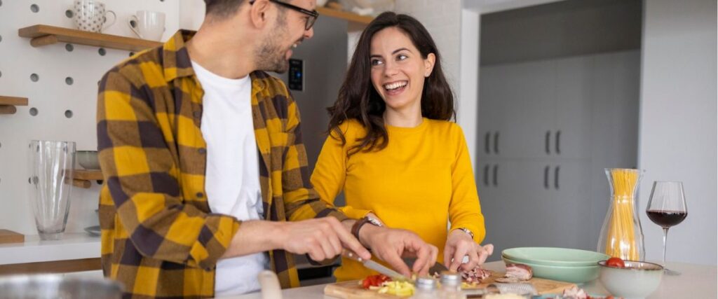 Imagem de casal na cozinha de casa preparando o jantar
