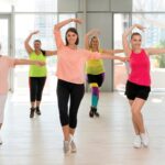 Imagem de alunos dançando Zumba na academia em busca dos benefícios da dança
