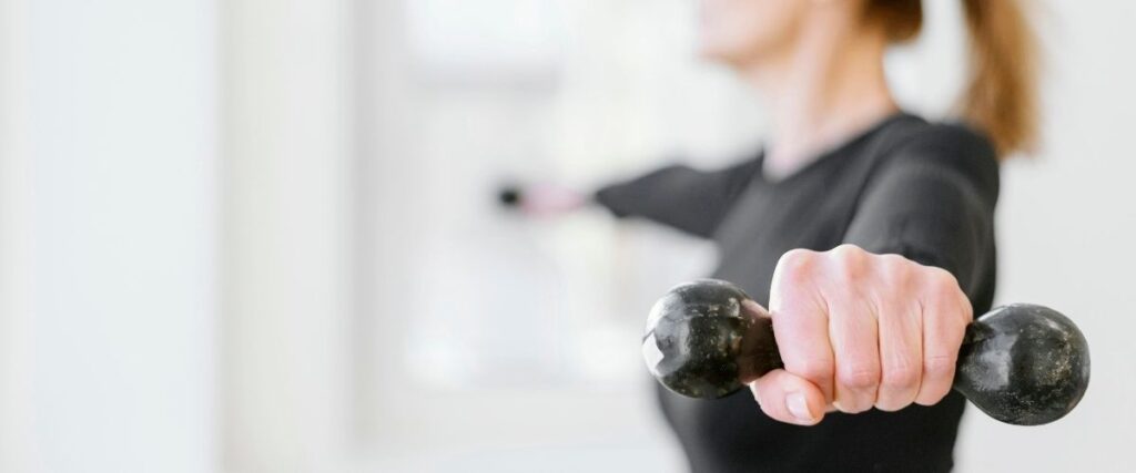 Imagem de uma mulher fazendo musculação