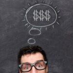 Imagem de metade do rosto de homem jovem com cifrões sobre a sua cabeça, simbolizando crenças limitantes sobre dinheiro