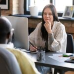 Imagem de um homem e uma mulher conversando no ambiente de trabalho, simbolizando a ideia de uma escuta ativa.