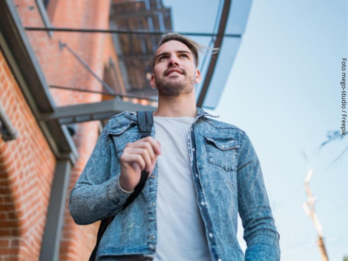 Imagem de um homem jovem branco a caminho do trabalho cheio de motivação para trabalhar.