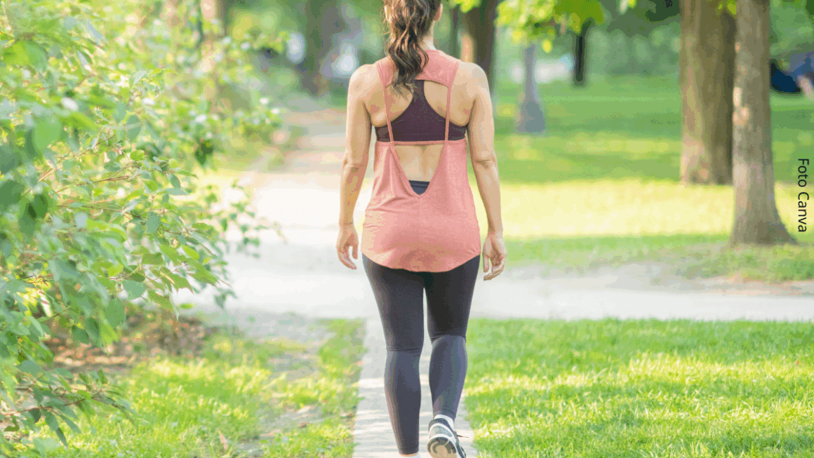 Imagem de uma mulher jovem branca andando em um parque, simbolizando uma caminhada meditativa.
