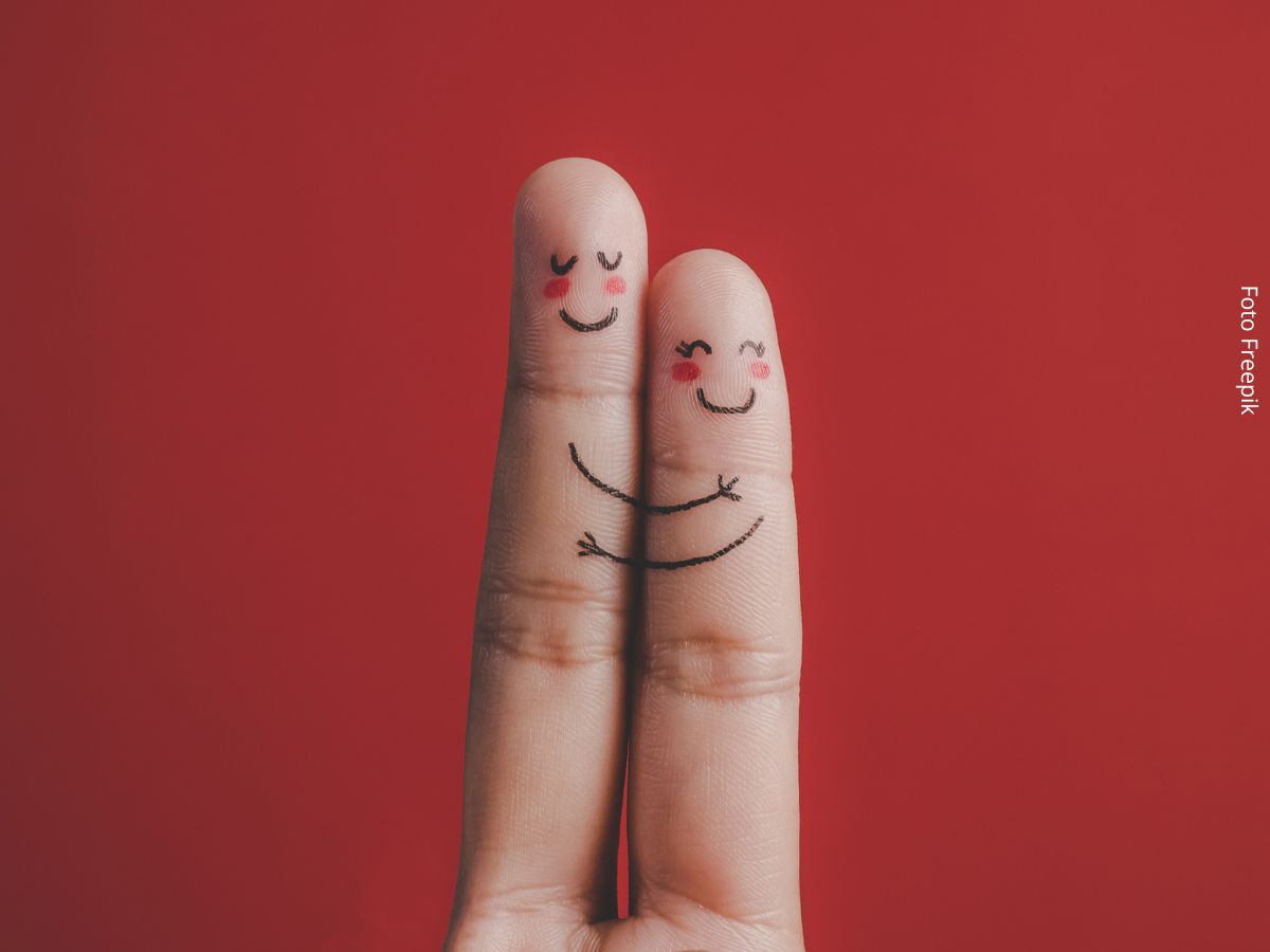 Imagem dos dedos indicador e do meio desenhados com rostos e se abraçando, sugerindo empatia emocional