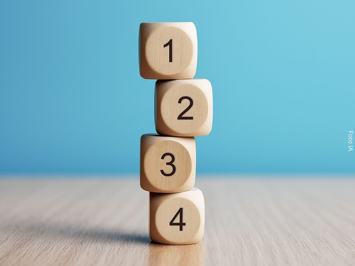 Imagem de quatro dados numerados de um a quatro empilhados sobre a mesa, como conceito de finanças equilibradas