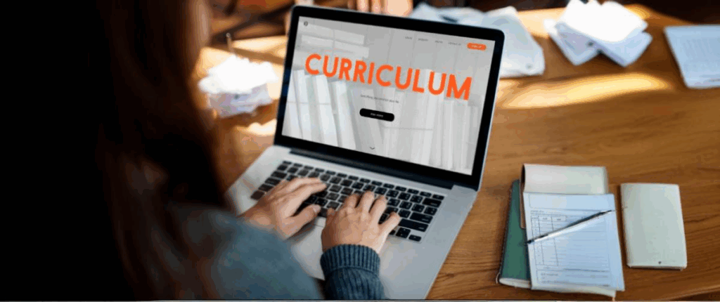 Imagem de uma mulher digitando currículo no laptop.