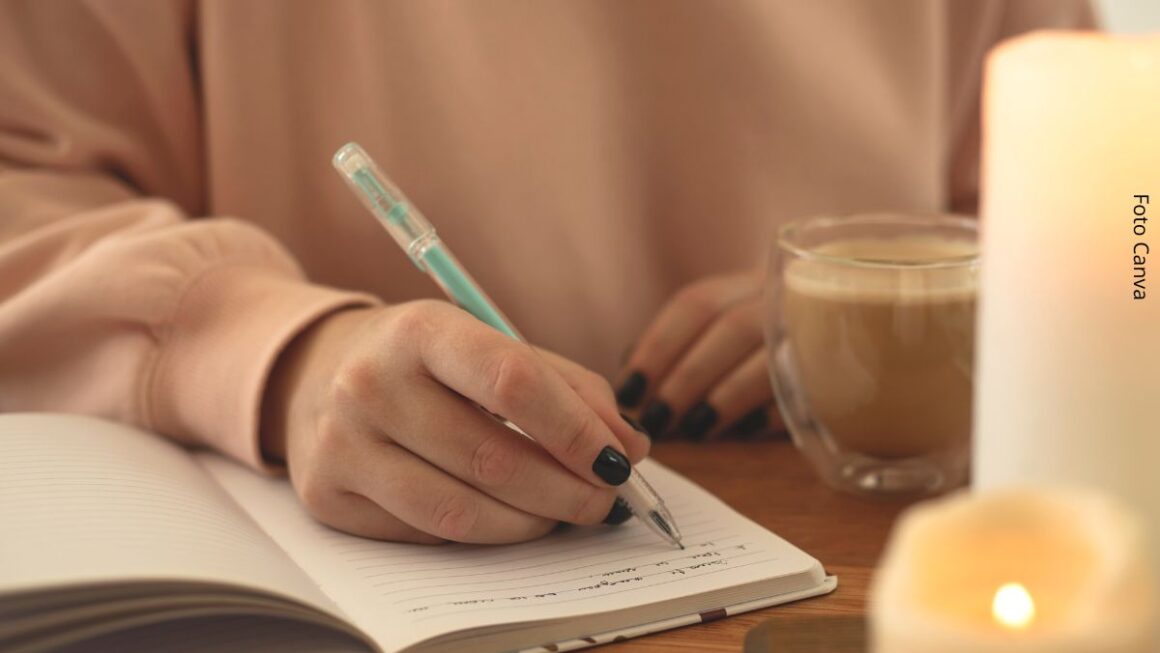 Close-up de uma mão feminina escrevendo em um caderno ou diário, simbolizando a ideia de ficar sozinho.