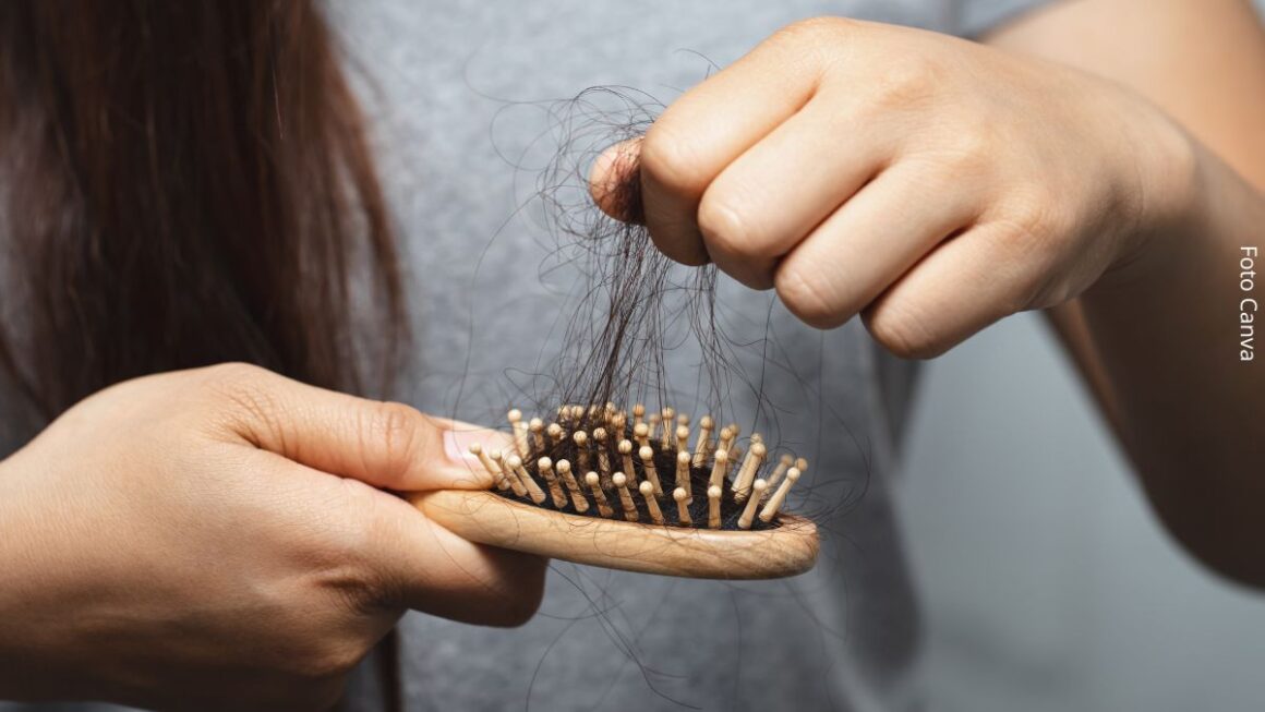 Imagem de uma mulher tirando chumaço de cabelo de uma escova após se pentear, simbolizando queda de cabelo